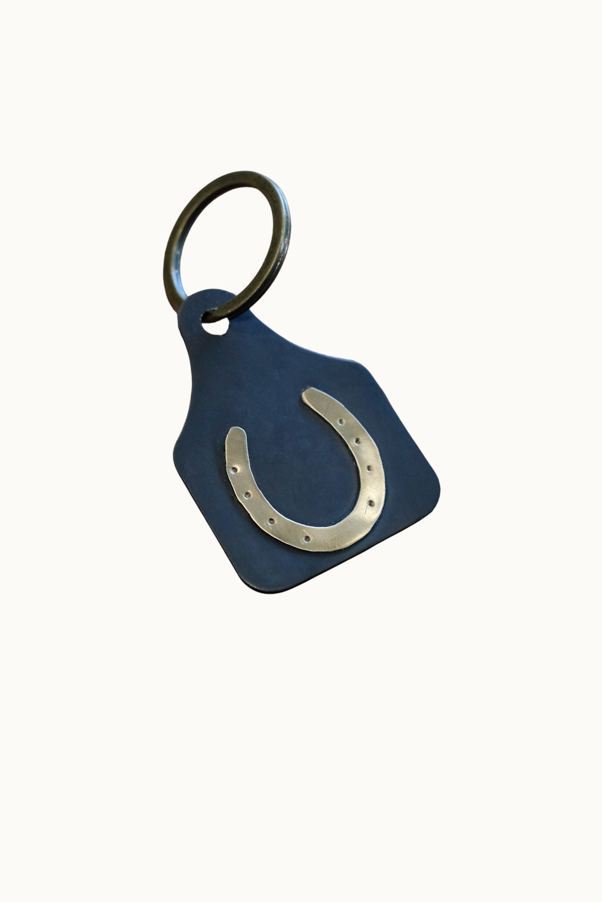 Wilkinson's Fine Goods horseshoe stock tag made of 16-gauge steel with a soldered brass horseshoe on a key ring.