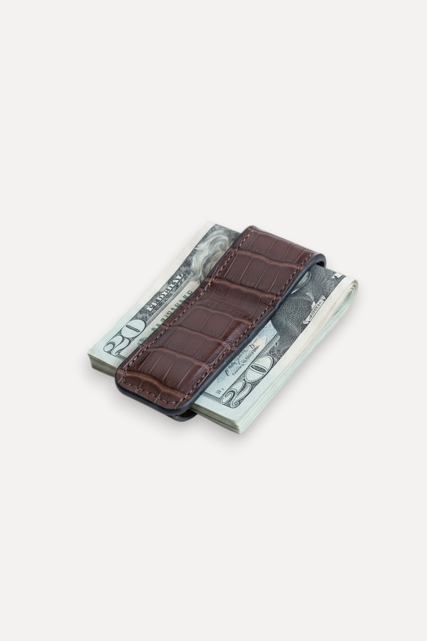 Wilkinson's Fine Goods brown alligator leather money clip with magnetic closure holding a stack of US dollar bills.