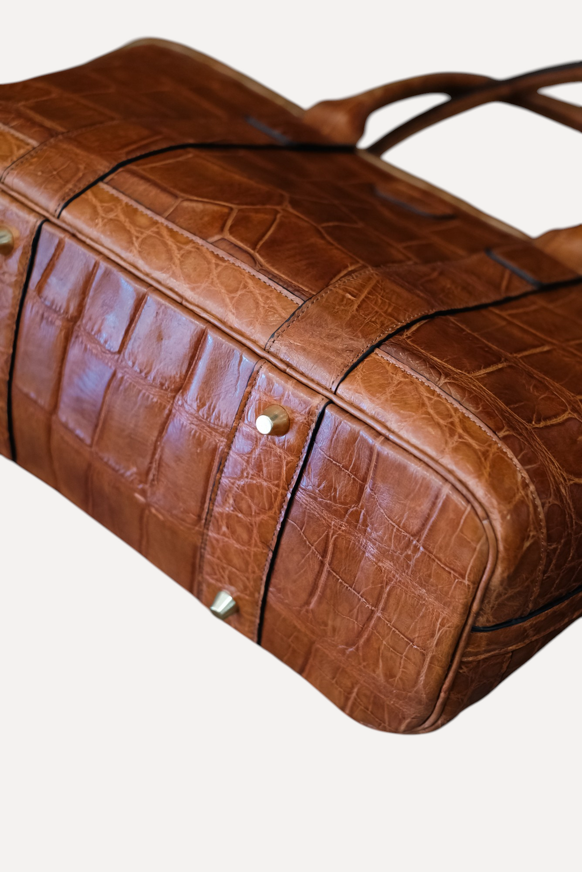 Wilkinson's Fine Goods brown American alligator leather Legacy bag featuring brass hardware feet and rolled handles.