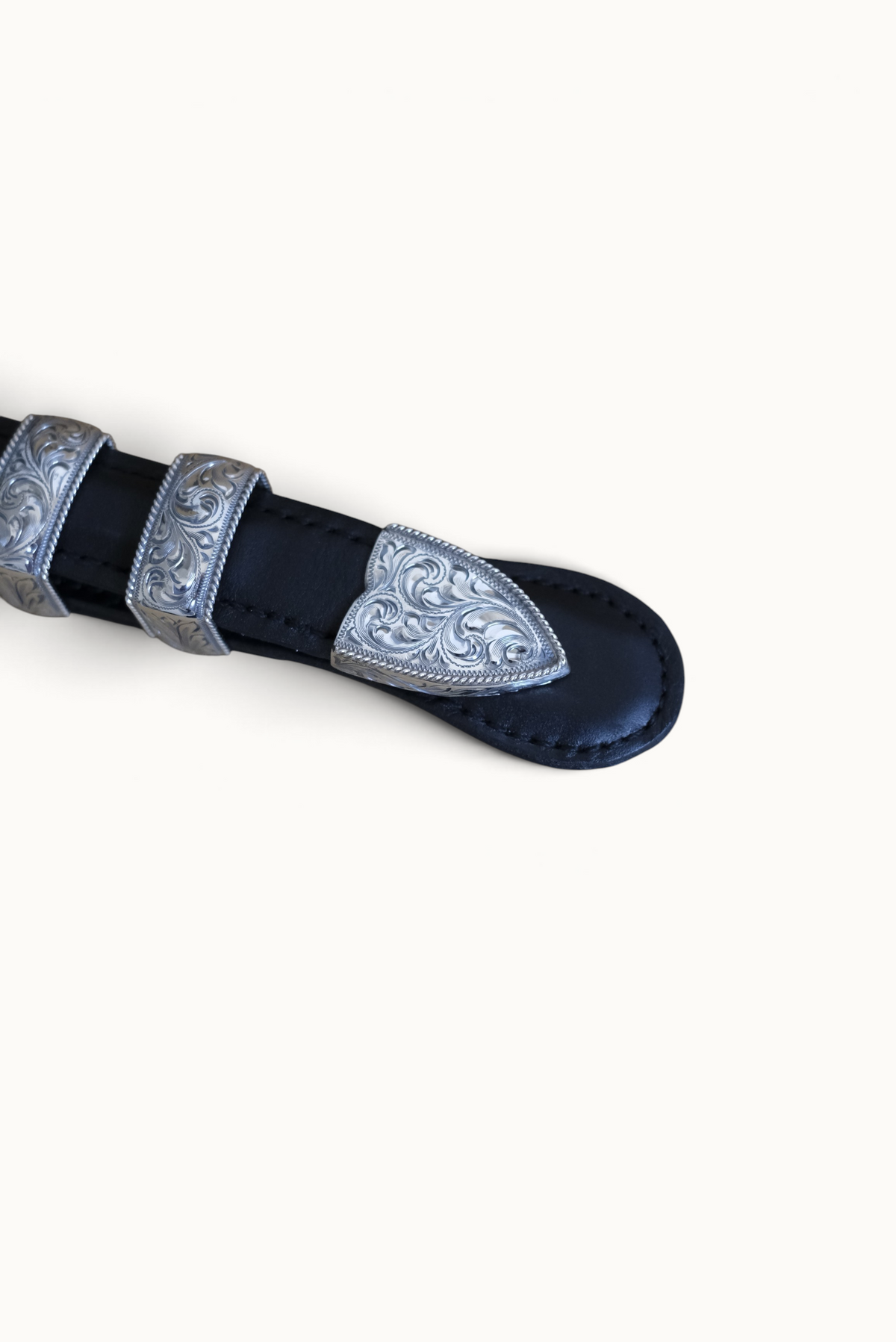 Wilkinson's Fine Goods The Senator buckle set featuring hand-engraved sterling silver tip on a black leather belt