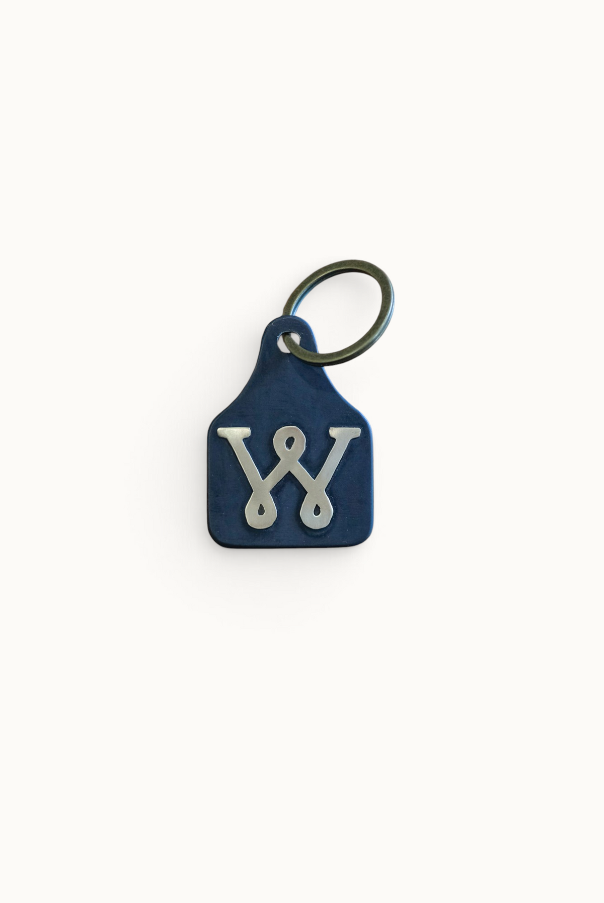 Wilkinson's Fine Goods Loop W Stock Tag featuring a hand-cut steel tag with a brass W inlay and metal keyring.