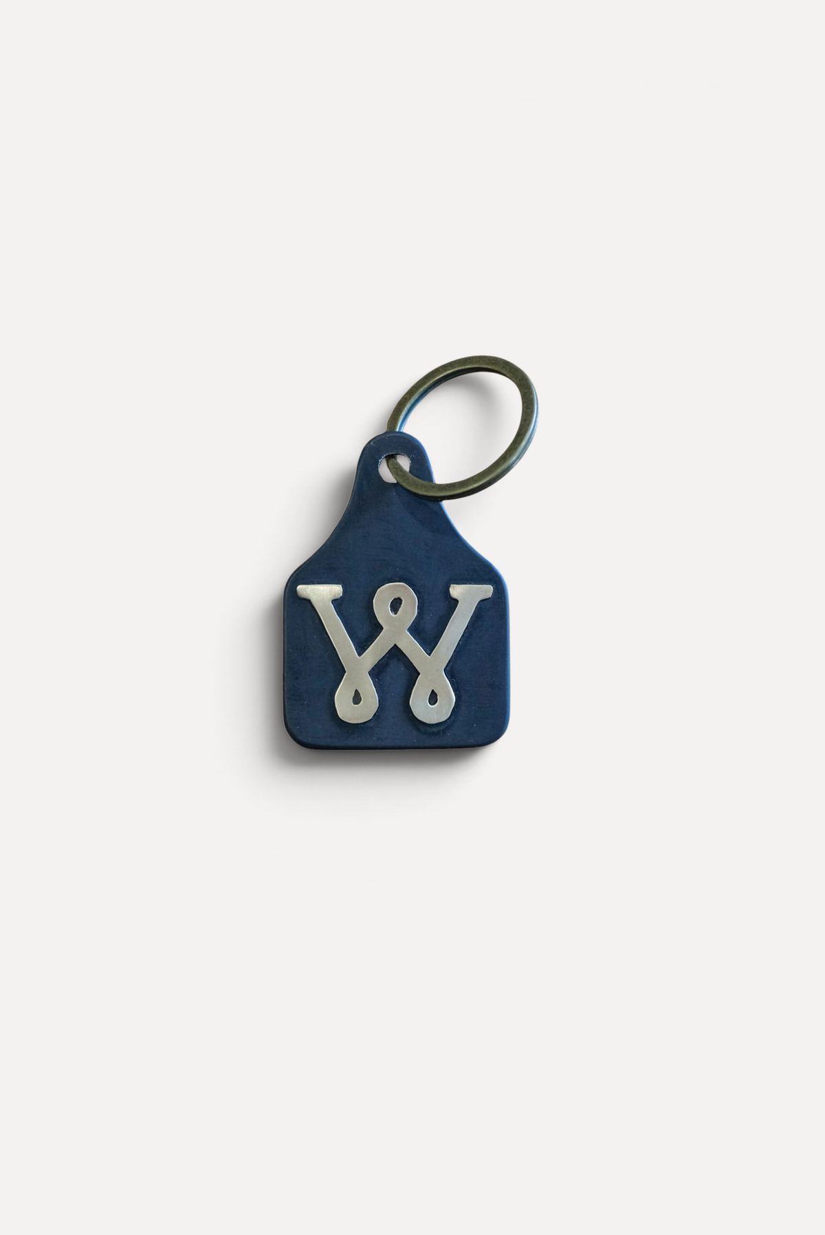 Wilkinson's Fine Goods Loop W Stock Tag featuring a hand-cut steel tag with a brass W inlay and metal keyring.