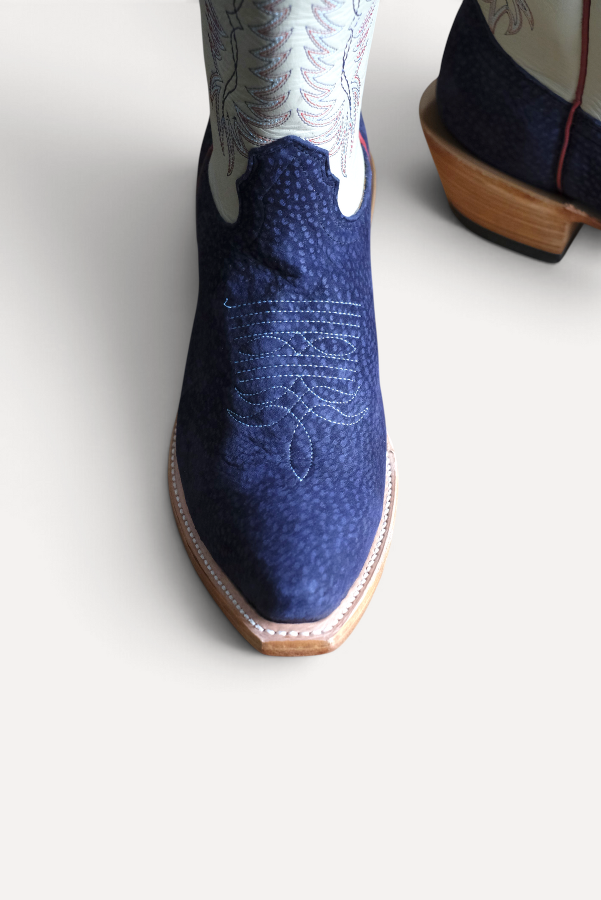 Close up of navy carpincho vamp with toe stitching and welt