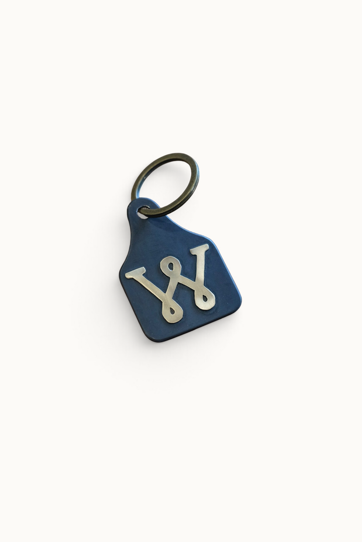 Wilkinson's Fine Goods Loop W stock tag made from hand-cut blue steel with a soldered brass W logo and keyring.