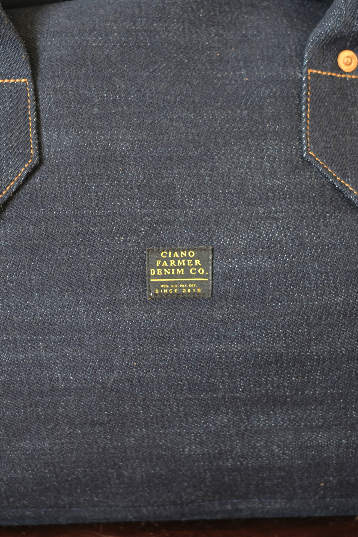 Wilkinson's Fine Goods Ciano Farmer Denim weekender bag featuring rugged dark denim fabric and a branded label.